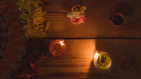 Beleuchtete-Diya-Lampen-Auf-Dem-Tisch,-Der-Für-Das-Diwali-Fest-Dekoriert-Ist,-Mit-Der-Statue-Von-Ganesh-1