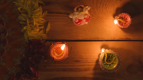 Hand,-Die-Diya-lampe-Auf-Den-Tisch-Stellt,-Der-Für-Das-Fest-Von-Diwali-Mit-Der-Statue-Von-Ganesh-Dekoriert-Ist-2