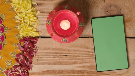 Tontopf-Mit-Lichtern-Zur-Feier-Der-Indischen-Hochzeit-Diwali-Oder-Navratri-Auf-Einem-Dekorierten-Tisch-Mit-Digitalem-Tablet-2