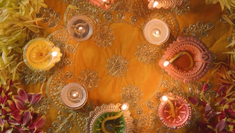 Overhead-Plattenspieleraufnahme-Von-Beleuchteten-Diya-Lampen-Auf-Einem-Tisch,-Der-Für-Das-Diwali-Fest-Dekoriert-Ist