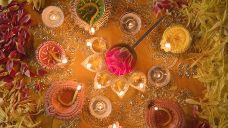 Overhead-Turntable-Shot-Of-Five-Wick-Lamp-On-Table-Decorated-For-Festival-Of-Diwali