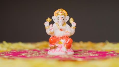 Hand,-Die-Die-Statue-Von-Ganesh-Vom-Tisch-Aufhebt,-Der-Für-Das-Fest-Von-Diwali-Dekoriert-Ist