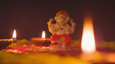 Estatua-De-Ganesh-En-La-Mesa-Decorada-Con-Lámparas-Diya-Para-Celebrar-El-Festival-De-Diwali-2