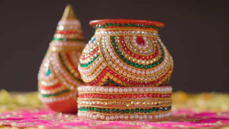 Hand-With-Traditional-Coconut-Pots-On-Table-Decorated-For-Celebrating-Festival-Of-Diwali