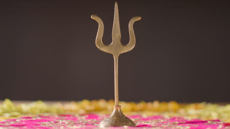 Trishula-Statue-Aus-Metall,-Göttliches-Dreizack-Symbol-Des-Hinduismus,-Auf-Geschmücktem-Tisch-1