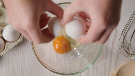 Overhead-Shot-Of-Kitchen-Utensils-On-Kitchen-Worktop-With-Person-Cracking-Egg-Into-Bowl-1