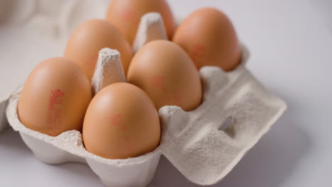 Studio-Shot-Of-Cardboard-Egg-Box-With-Brown-Eggs-On-Marble-Work-Surface-Background