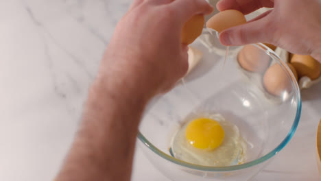Overhead-Shot-Of-Kitchen-Utensils-On-Kitchen-Worktop-With-Person-Cracking-Egg-Into-Bowl-2