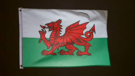 Studioaufnahme-Der-Flagge-Von-Wales,-Die-Vor-Schwarzem-Hintergrund-Fliegt