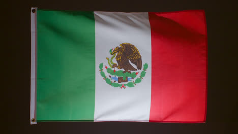 Studioaufnahme-Der-Flagge-Mexikos,-Die-Vor-Schwarzem-Hintergrund-Herunterfällt