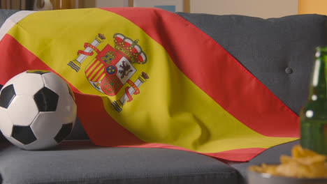 Flag-Of-Spain-Draped-Over-Sofa-At-Home-With-Football-Ready-For-Match-On-TV-1