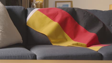 Close-Up-Of-Flag-Of-Germany-Draped-Over-Sofa-At-Home-Ready-For-Match-On-TV-1