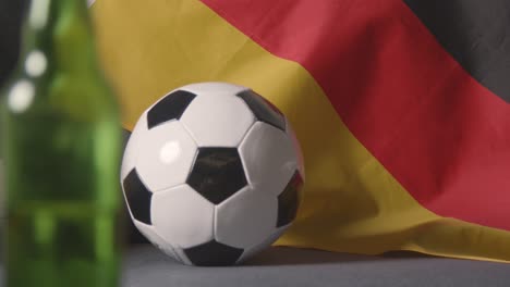 Flag-Of-Germany-Draped-Over-Sofa-At-Home-With-Football-Ready-For-Match-On-TV-2