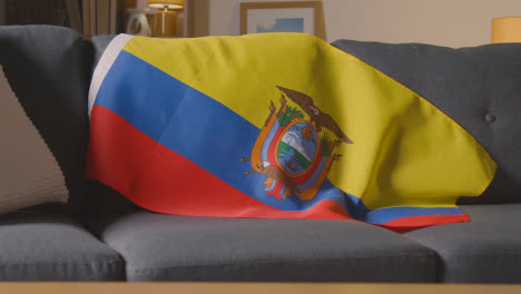Primer-Plano-De-La-Bandera-De-Ecuador-Sobre-Un-Sofá-En-Casa-Con-Fútbol-Listo-Para-El-Partido-En-Tv-1