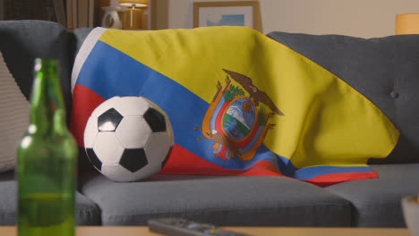 Bandera-De-Ecuador-Sobre-Un-Sofá-En-Casa-Con-Fútbol-Listo-Para-El-Partido-En-La-Televisión