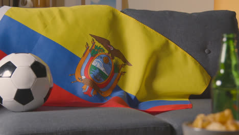 Bandera-De-Ecuador-Sobre-Un-Sofá-En-Casa-Con-Fútbol-Listo-Para-El-Partido-En-Tv-1