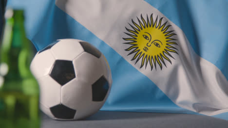Flag-Of-Argentina-Draped-Over-Sofa-At-Home-With-Football-Ready-For-Match-On-TV-2