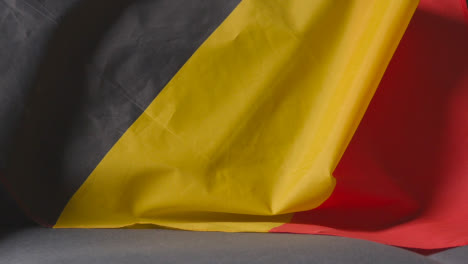 Nahaufnahme-Der-Flagge-Von-Belgien,-Die-Zu-Hause-über-Dem-Sofa-Drapiert-Ist,-Bereit-Für-Das-Spiel-Im-Fernsehen