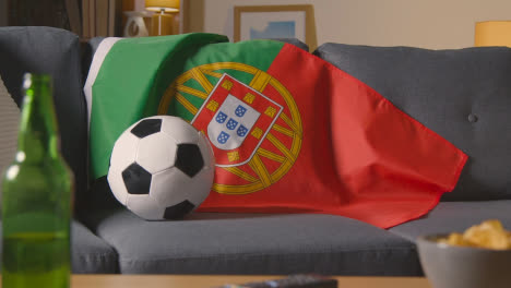 Bandera-De-Portugal-Sobre-Un-Sofá-En-Casa-Con-Fútbol-Listo-Para-El-Partido-En-Tv-1