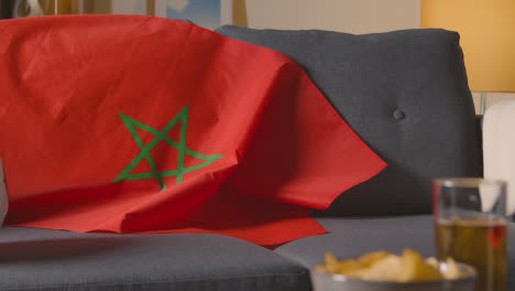 Flag-Of-Morocco-Draped-Over-Sofa-At-Home-With-Football-Ready-For-Match-On-TV-2