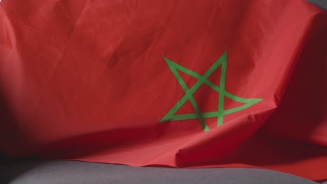 Close-Up-Of-Flag-Of-Morocco-Draped-Over-Sofa-At-Home-Ready-For-Match-On-TV