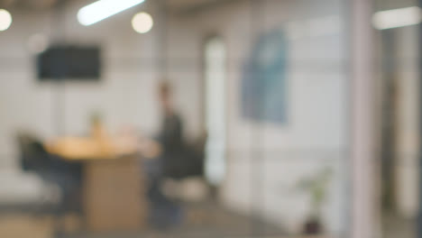 Defocused-Background-Shot-Of-Businesspeople-Working-At-Desk-In-Office-And-Talking-On-Phone-2