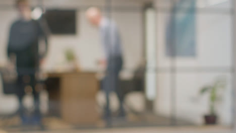 Defocused-Background-Shot-Of-Businesspeople-At-Work-In-Office-Having-Meeting-At-Desk-2