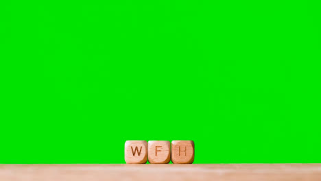 Business-Concept-Wooden-Letter-Cubes-Or-Dice-Spelling-WFH-Against-Green-Screen