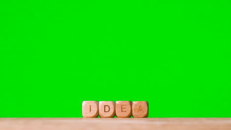 Business-Concept-Wooden-Letter-Cubes-Or-Dice-Spelling-Idea-Against-Green-Screen