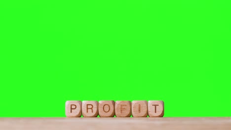 Business-Concept-Wooden-Letter-Cubes-Or-Dice-Spelling-Profit-Against-Green-Screen