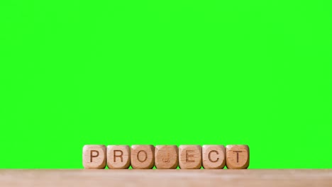 Business-Concept-Wooden-Letter-Cubes-Or-Dice-Spelling-Project-Against-Green-Screen