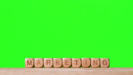 Business-Concept-Wooden-Letter-Cubes-Or-Dice-Spelling-Marketing-Against-Green-Screen