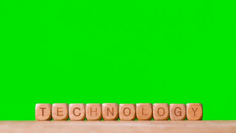 Business-Concept-Wooden-Letter-Cubes-Or-Dice-Spelling-Technology-Against-Green-Screen