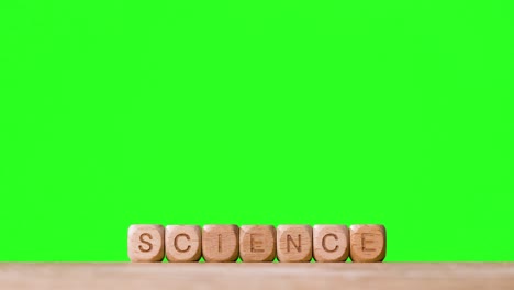 Education-Concept-With-Wooden-Letter-Cubes-Or-Dice-Spelling-Science-Against-Green-Screen-Background