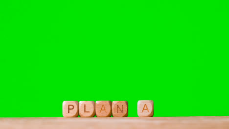 Concept-With-Wooden-Letter-Cubes-Or-Dice-Spelling-Plan-A-Against-Green-Screen