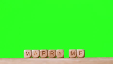 Concept-With-Wooden-Letter-Cubes-Or-Dice-Spelling-Marry-Me-Against-Green-Screen-Background