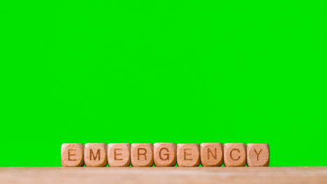 Medical-Concept-With-Wooden-Letter-Cubes-Or-Dice-Spelling-Emergency-Against-Green-Screen-Background