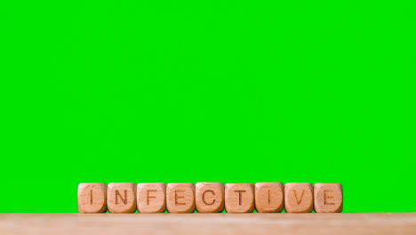 Medical-Concept-With-Wooden-Letter-Cubes-Or-Dice-Spelling-Infective-Against-Green-Screen-Background