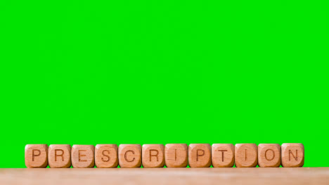 Medical-Concept-With-Wooden-Letter-Cubes-Or-Dice-Spelling-Prescription-Against-Green-Screen