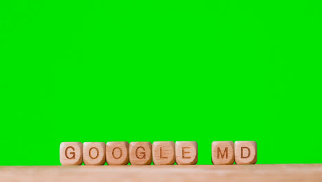 Medical-Concept-With-Wooden-Letter-Cubes-Or-Dice-Spelling-Google-MD-Against-Green-Screen-Background