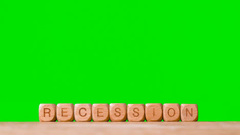 Concept-With-Wooden-Letter-Cubes-Or-Dice-Spelling-Recession-Against-Green-Screen-Background