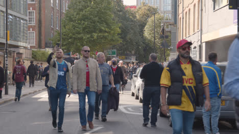 Fans-Walking-Through-Streets-Near-he-Emirates-Stadium-Home-Ground-Arsenal-Football-Club-London-With-Supporters-On-Match-Day