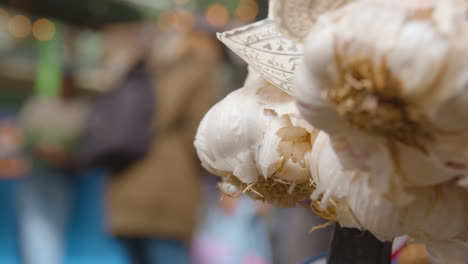 Close-Up-Of-Garlic-Bulbs-Inside-Borough-Market-London-UK-With-Food-Stalls-And-Tourist-Visitors