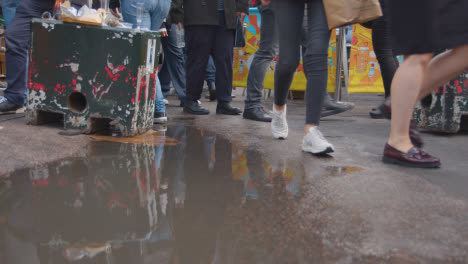 Close-Up-Of-Tourists-Feet-As-They-Walk-Through-Borough-Market-London-UK