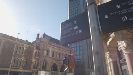 Signpost-In-City-Of-Cardiff-Wales-With-New-And-Old-Buildings-In-Background