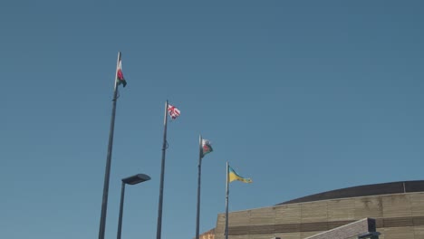 Welsh-English-And-Ukrainian-Flags-Flying-Against-Blue-Sky