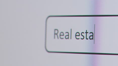 Close-Up-Of-Screen-With-Person-Typing-Real-Estate-Agent-Into-Computer-Search-Engine