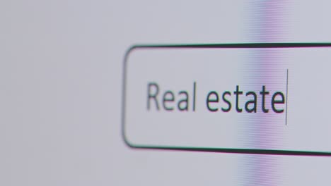 Close-Up-Of-Screen-With-Person-Typing-Real-Estate-Market-Into-Computer-Search-Engine