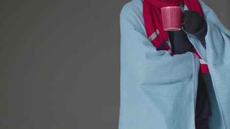 Close-Up-Of-Person-Wearing-Blanket-With-Hot-Drink-Trying-To-Keep-Warm-In-Energy-Crisis-3