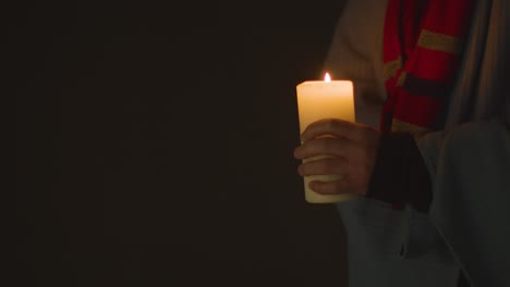 Close-Up-Of-Person-Wrapped-In-Blanket-Holding-Candle-To-Save-Electricity-1
